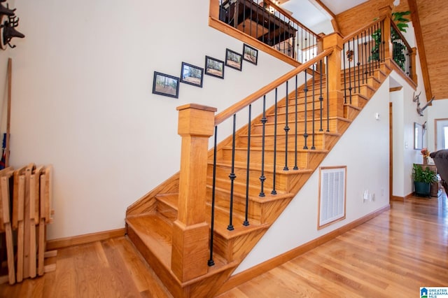 395 Creek Run Rd, Wedowee, AL 36278 - stairway with visible vents, baseboards, radiator heating unit, a towering ceiling, and wood finished floors