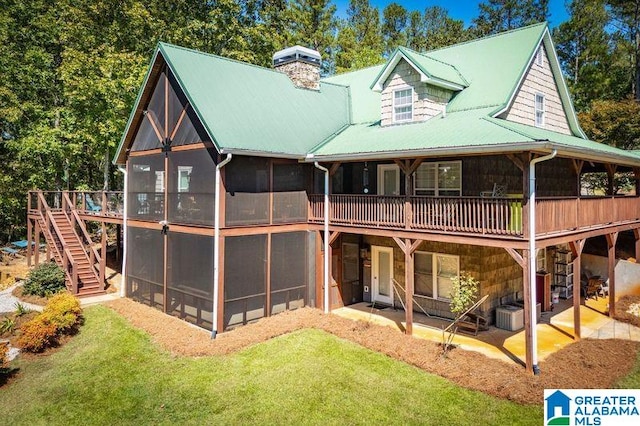 rear view of house featuring a yard, a patio, and a sunroom