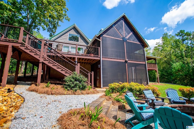 rear view of property with a deck and a sunroom