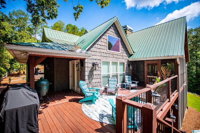 deck with a sunroom and area for grilling