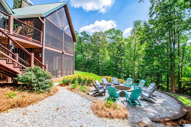 exterior space with an outdoor fire pit and a sunroom