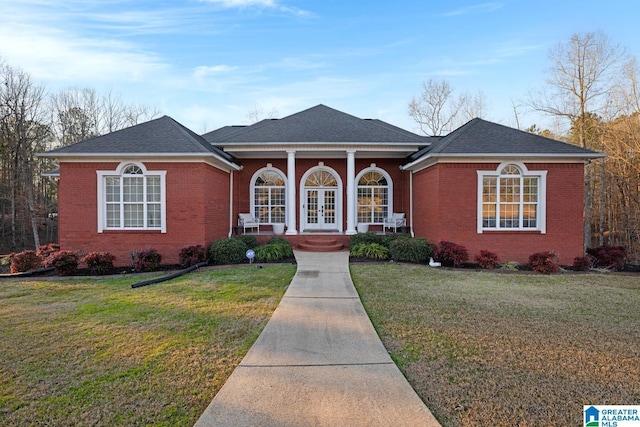 ranch-style home featuring a front lawn, covered porch, and french doors