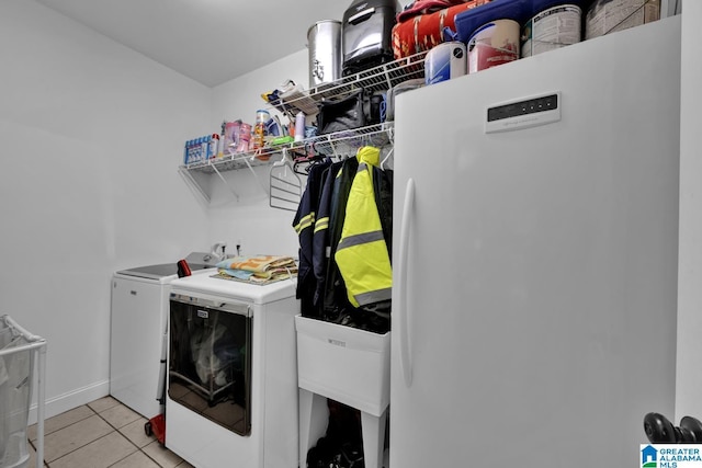 laundry area with washer and clothes dryer and light tile patterned floors