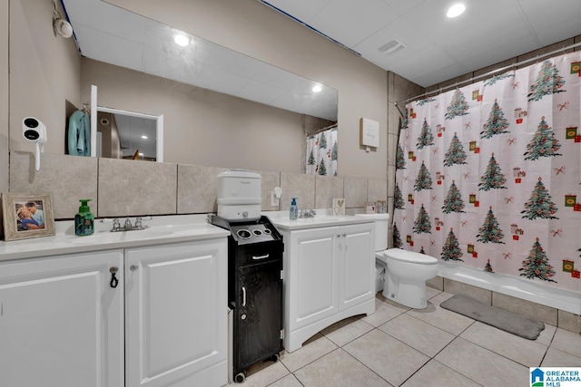 full bathroom with tasteful backsplash, tile patterned flooring, toilet, vanity, and tile walls