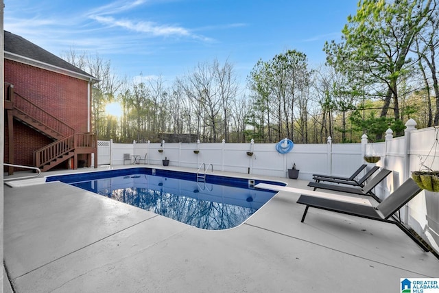 view of swimming pool with a patio and a diving board