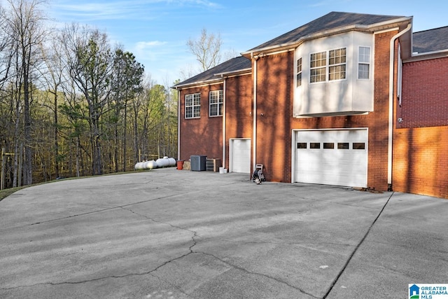 view of side of property with cooling unit and a garage