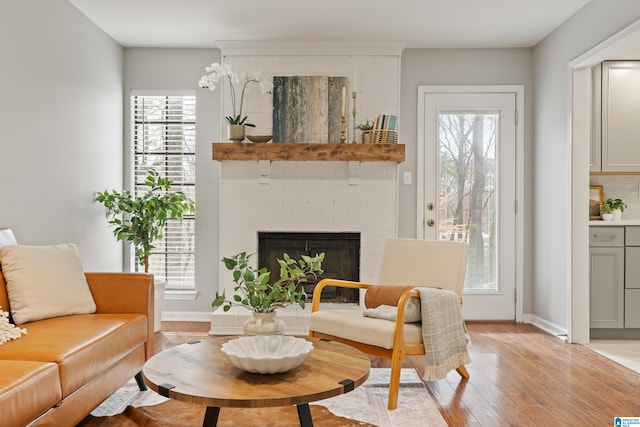 living area with plenty of natural light, light hardwood / wood-style floors, and a fireplace