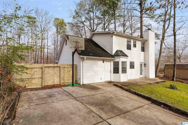 back of house featuring a patio area and a lawn