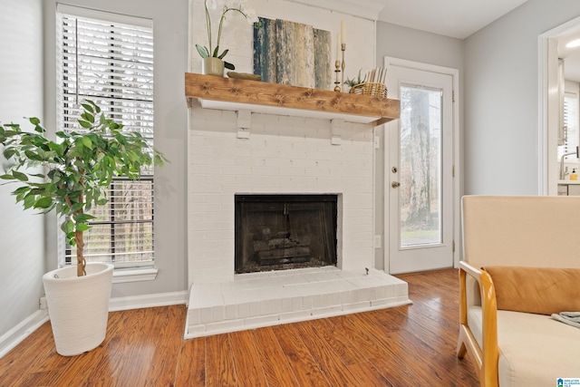 interior space featuring hardwood / wood-style flooring and a brick fireplace