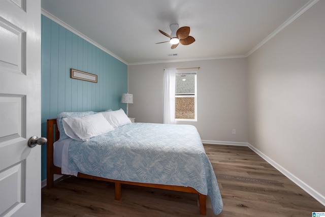 bedroom with wood walls, ceiling fan, hardwood / wood-style flooring, and ornamental molding