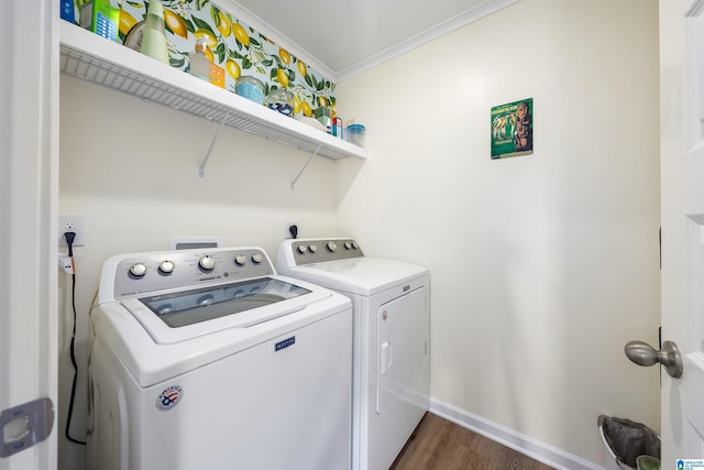 laundry room featuring ornamental molding, dark hardwood / wood-style flooring, and washing machine and clothes dryer