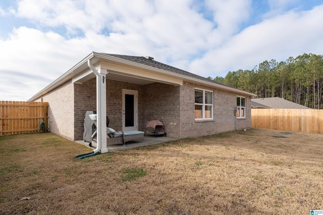 back of property with a lawn and a patio area