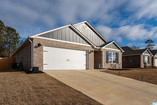 view of front of property featuring cooling unit, a garage, and a front yard