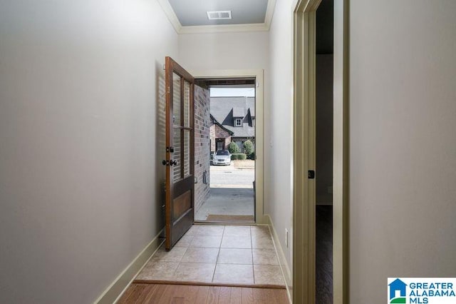 doorway featuring light wood-type flooring and ornamental molding