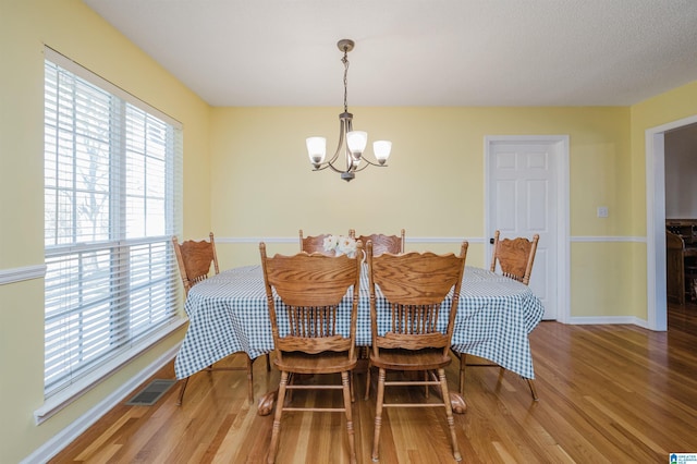 dining room with a notable chandelier and wood-type flooring