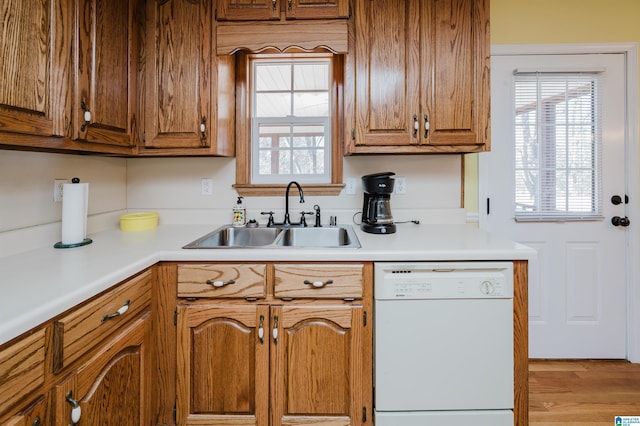 kitchen with white dishwasher, light hardwood / wood-style floors, and sink