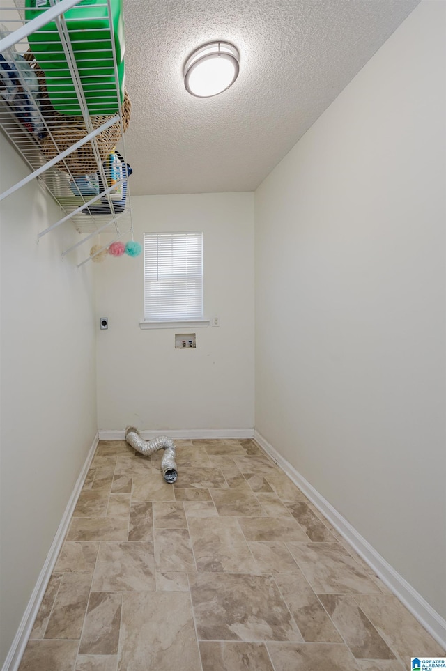 clothes washing area with washer hookup, a textured ceiling, and hookup for an electric dryer