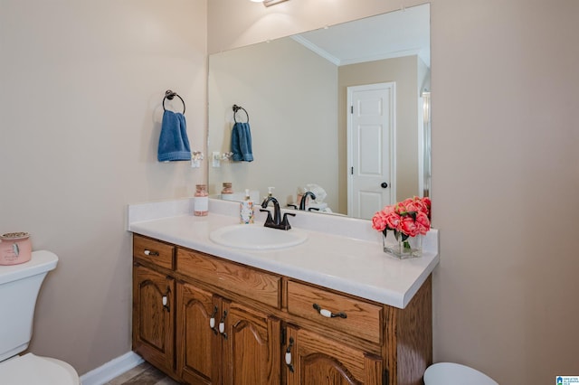 bathroom featuring crown molding, vanity, and toilet