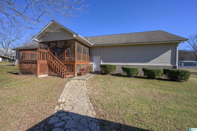 exterior space with a front yard, a wooden deck, and a sunroom