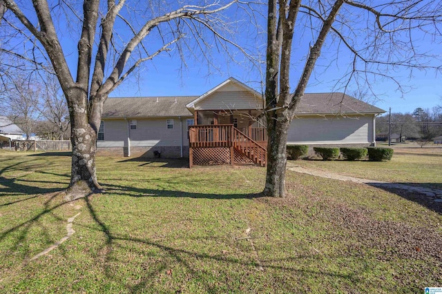 view of front of property with a wooden deck and a front lawn