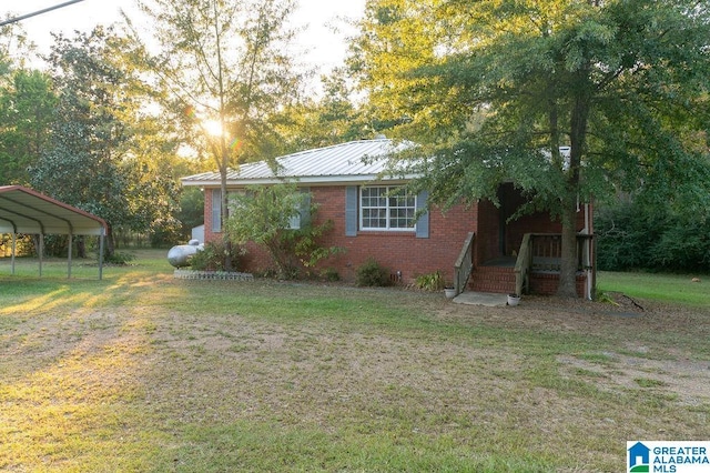 view of side of property featuring a carport and a yard