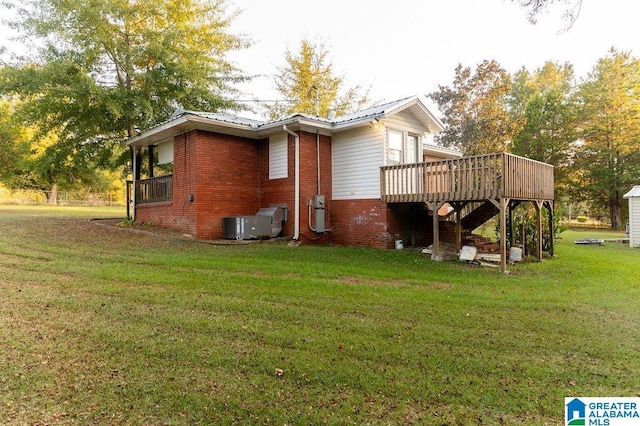 rear view of property featuring a wooden deck, a yard, and cooling unit