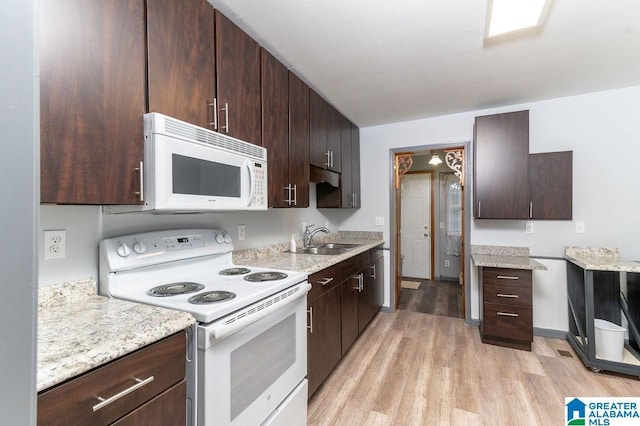 kitchen featuring dark brown cabinetry, white appliances, sink, and light hardwood / wood-style flooring