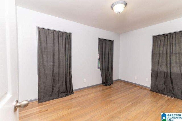 unfurnished room with wood-type flooring