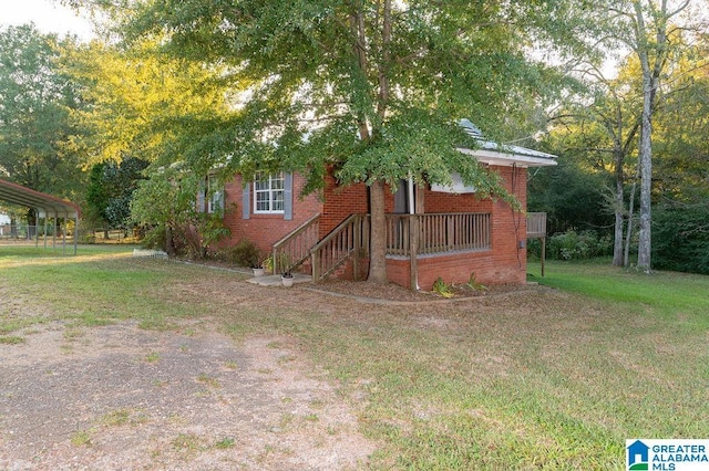 view of property hidden behind natural elements with a front yard and a carport