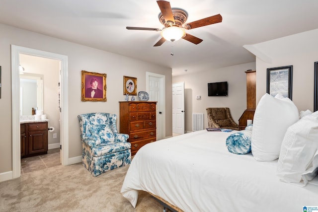 bedroom with ensuite bath, ceiling fan, and light colored carpet