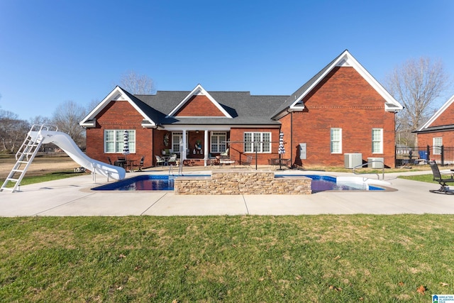 rear view of property with a yard, a patio, and central AC