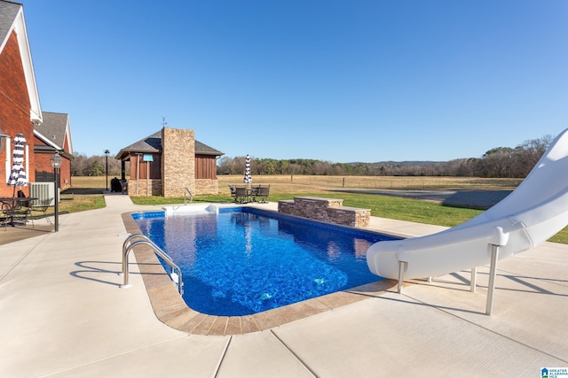 view of swimming pool featuring a water slide and a patio