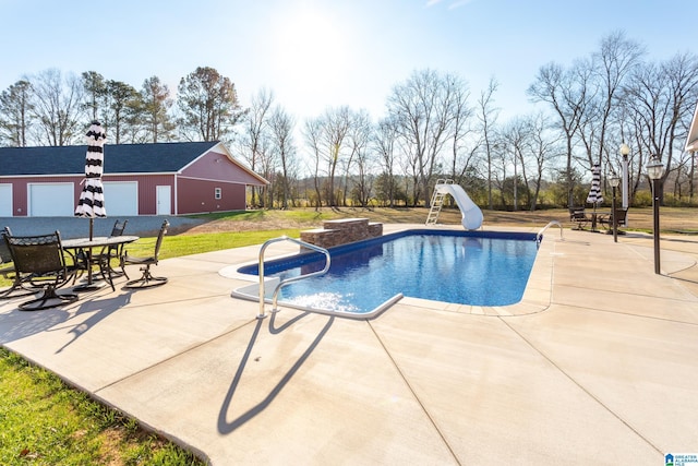 view of swimming pool featuring a patio and a water slide