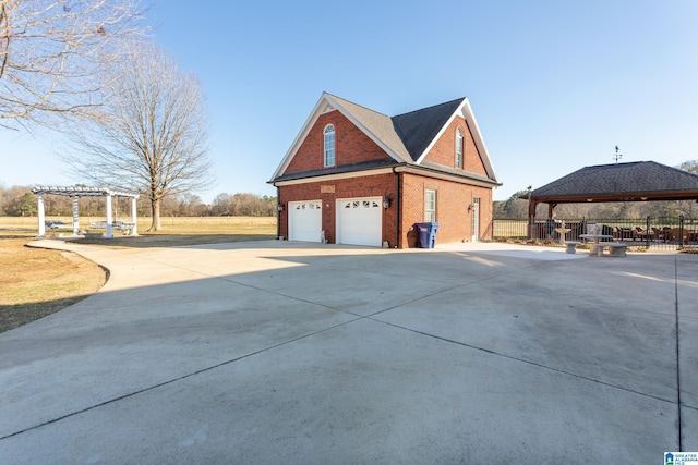 view of side of property with a gazebo, a pergola, and a garage