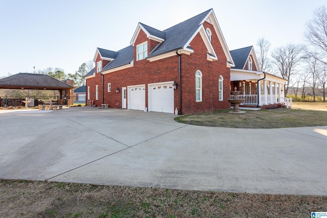 view of home's exterior with a gazebo, covered porch, and a garage