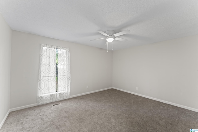 empty room with carpet, ceiling fan, and a textured ceiling