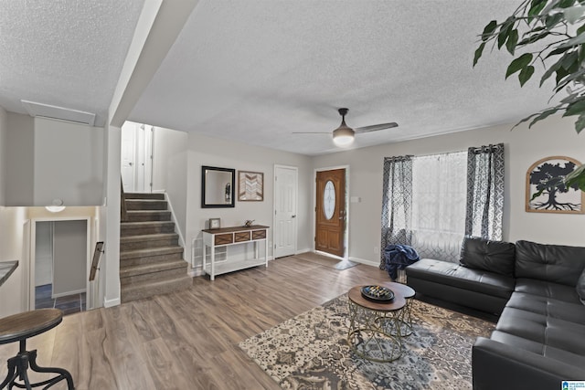 living room with hardwood / wood-style floors, a textured ceiling, and ceiling fan