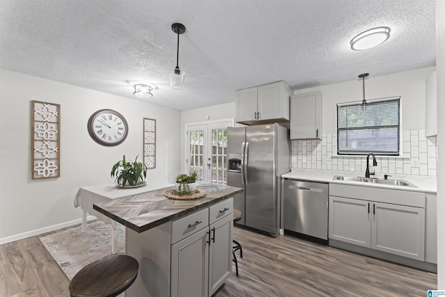 kitchen with pendant lighting, stainless steel appliances, tasteful backsplash, and gray cabinetry