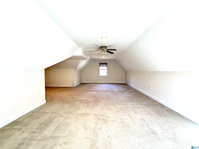 bonus room with ceiling fan, light colored carpet, a textured ceiling, and vaulted ceiling