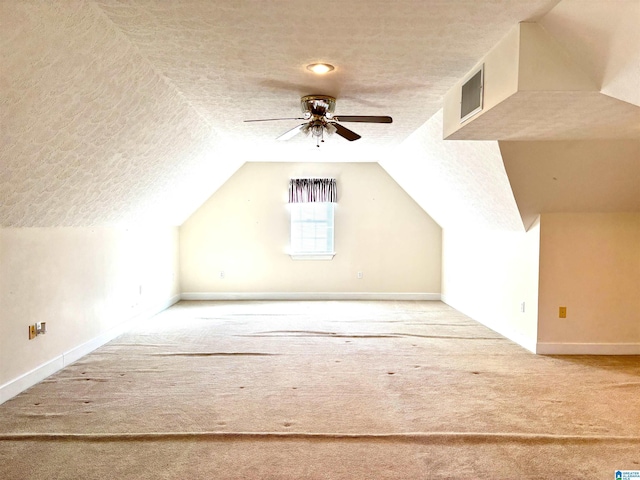 bonus room with lofted ceiling, ceiling fan, carpet flooring, and a textured ceiling