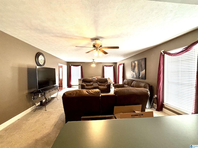 living room with a textured ceiling, ceiling fan, and light carpet