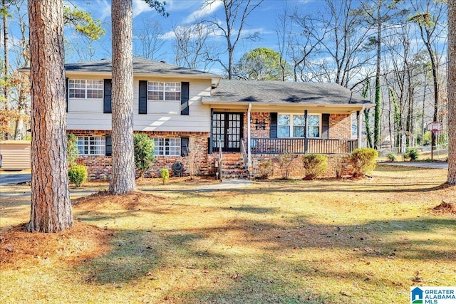 tri-level home with covered porch and a front yard