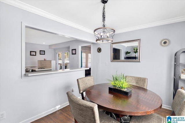 dining space featuring dark hardwood / wood-style floors, crown molding, and an inviting chandelier