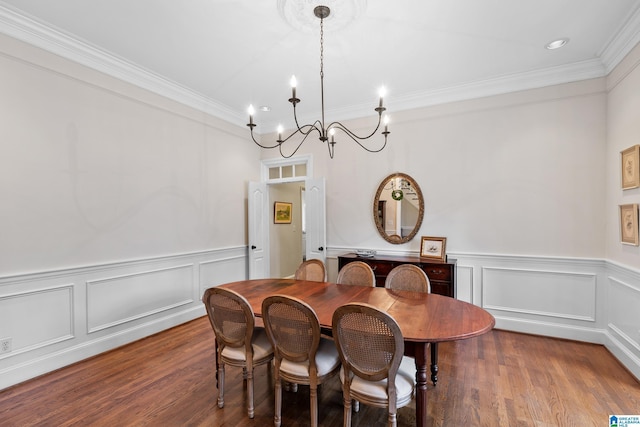 dining room featuring dark hardwood / wood-style floors, an inviting chandelier, and ornamental molding