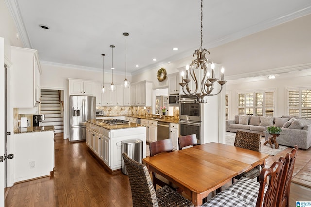 dining space with crown molding, sink, a chandelier, and dark hardwood / wood-style floors