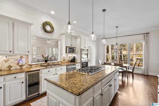 kitchen with wine cooler, white cabinetry, a kitchen island, and pendant lighting