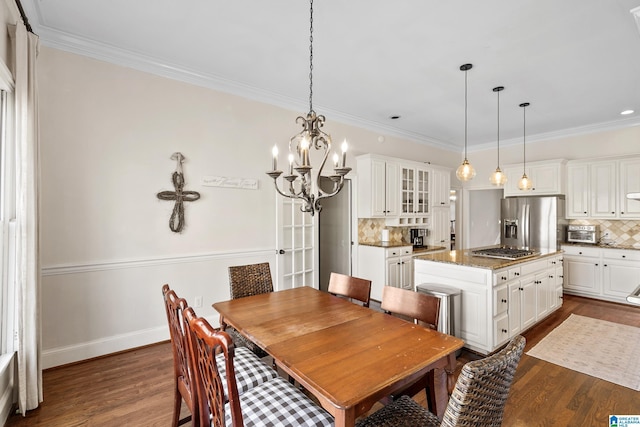 dining area featuring a notable chandelier, dark hardwood / wood-style floors, and ornamental molding