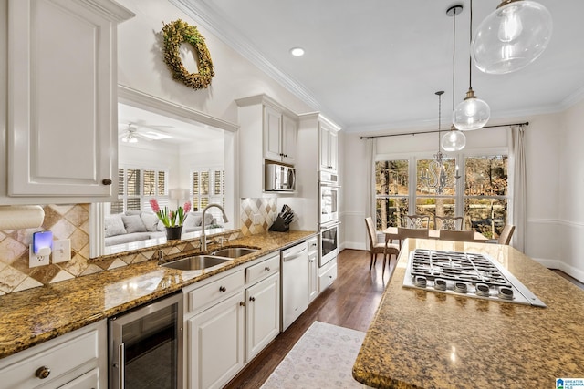 kitchen with sink, white cabinets, beverage cooler, and appliances with stainless steel finishes