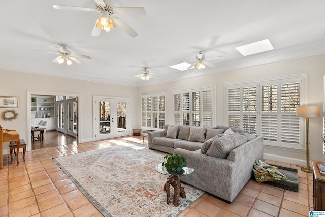 tiled living room featuring a healthy amount of sunlight, french doors, ornamental molding, and a skylight