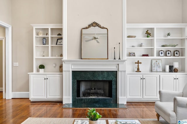 living room with ceiling fan, wood-type flooring, and a fireplace